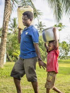 Thomas walks with his daughter to collect water in drought-ravaged PNG. [Credit: Luke Vodell]