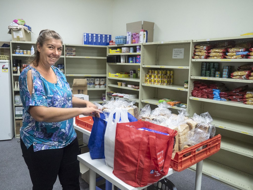 An ADRA volunteer prepares emergency food parcels